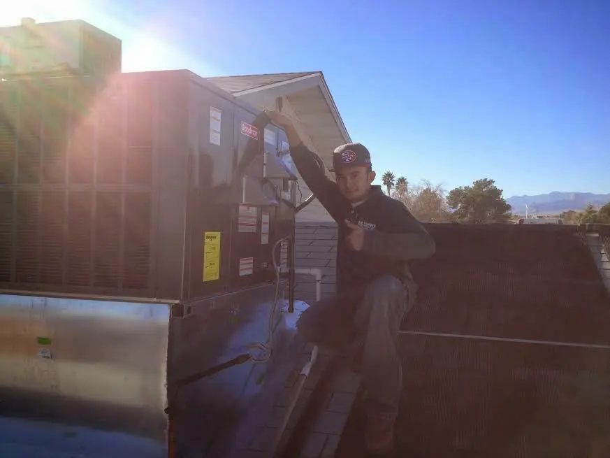 HVAC technician performing Air Duct Cleaning on a rooftop unit in Gardnerville Ranchos